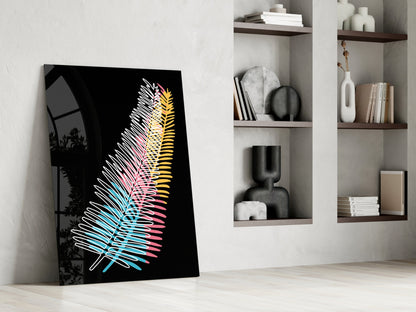 Colorful fern glass wall art with neon cyan, pink, and yellow leaf lines on black background, leaning against wall beside white shelving unit.