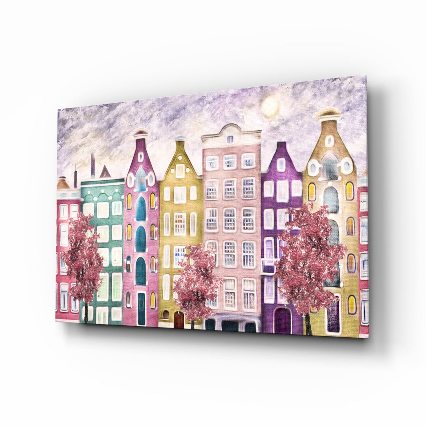 Angled perspective view of colorful glass wall art depicting a whimsical row of pastel buildings with distinctive peaked roofs, flowering trees, and moonlit sky.