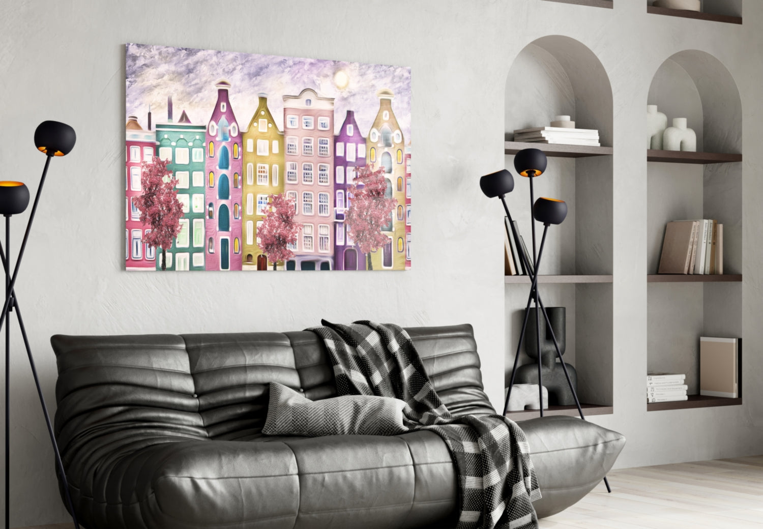 Colorful glass wall art depicting whimsical pastel buildings displayed above black leather sofa in modern living room setting.