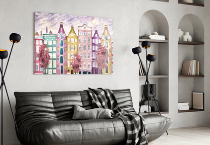Colorful glass wall art depicting whimsical pastel buildings displayed above black leather sofa in modern living room setting.