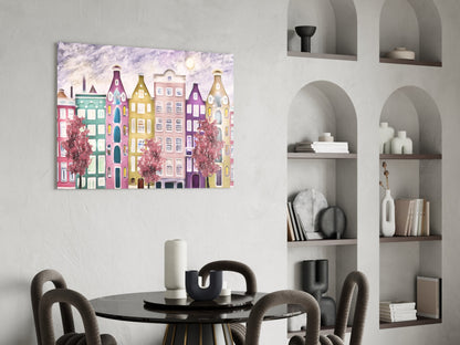 Colorful glass art depicting whimsical European architecture displayed above a dining table in a modern interior setting.