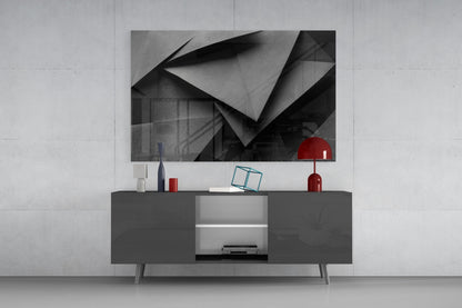 Modern living room setup featuring geometric black and white wall art above dark media console with red decorative accents.