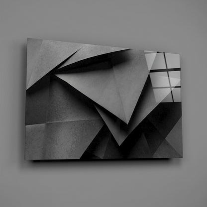 Monochromatic glass wall art displaying overlapping geometric planes with sharp shadows and gradated grayscale tones on neutral background.