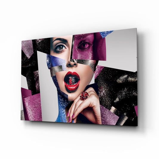 Angled view of glass wall art featuring a woman's face with bold red lips, geometric glitter sections in purple, blue, black, and silver, mounted on white background.