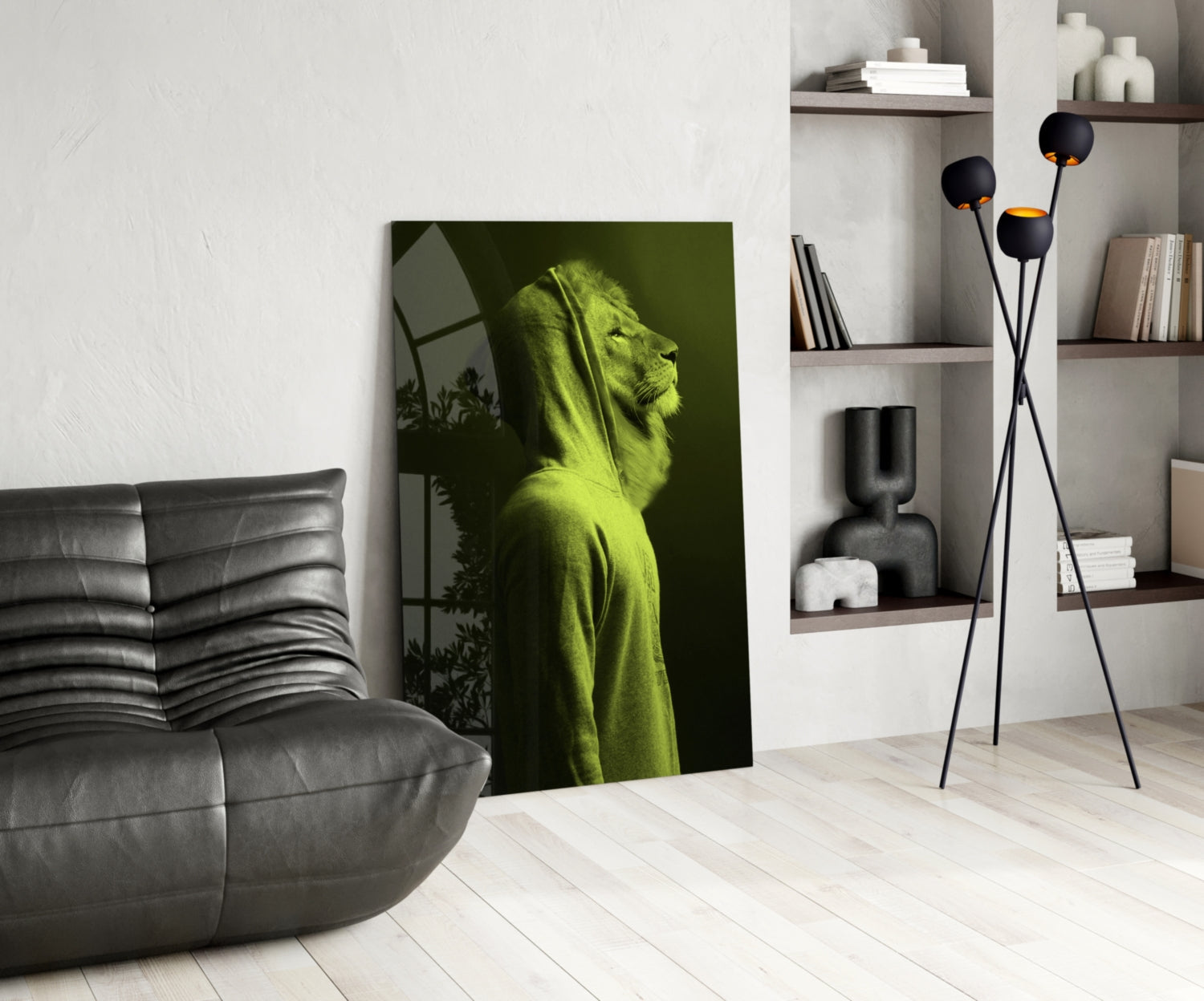 Green lion head glass wall art leaning against white wall in modern living room with gray sofa and shelving.