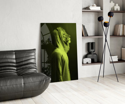 Green lion head glass wall art leaning against white wall in modern living room with gray sofa and shelving.