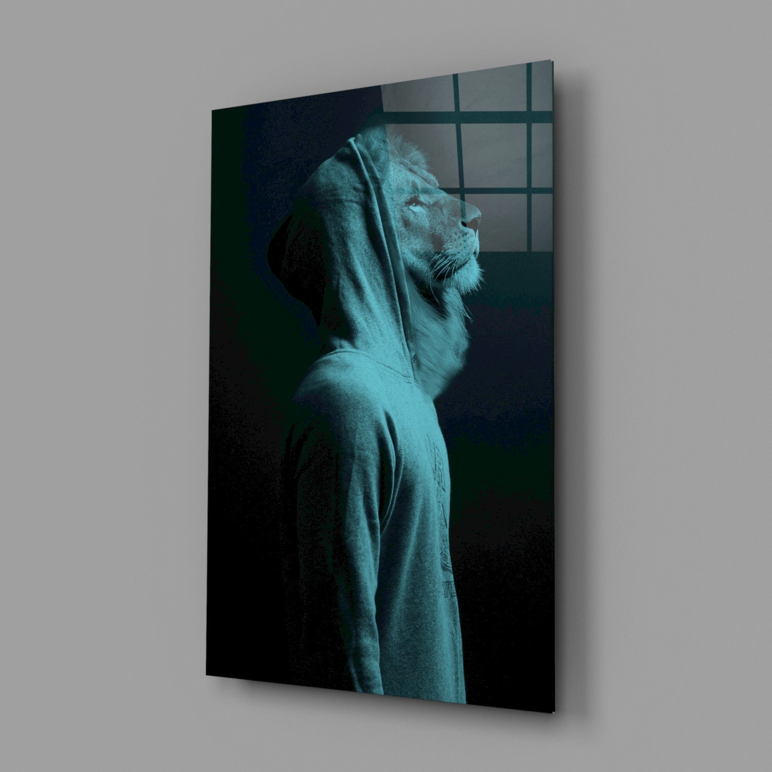 Blue-toned lion head profile in hoodie on dark glass panel, displayed at angle against gray wall.