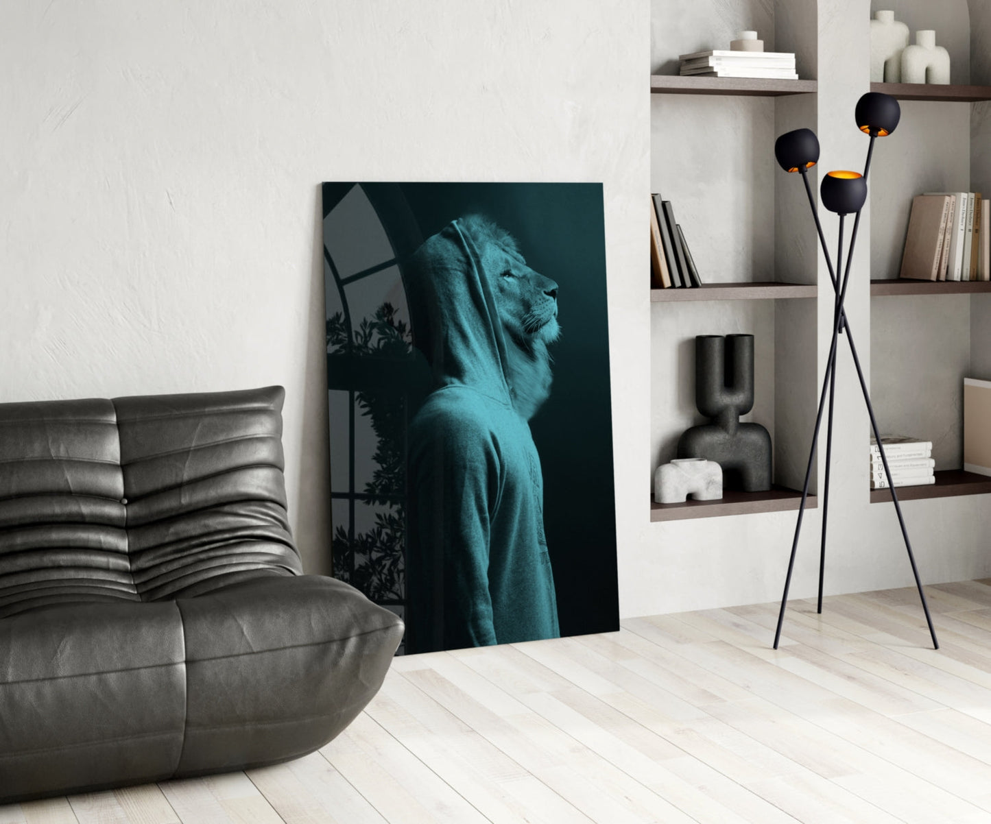 Blue tinted lion head glass art leaning against white wall in modern living room with gray sofa and shelving.