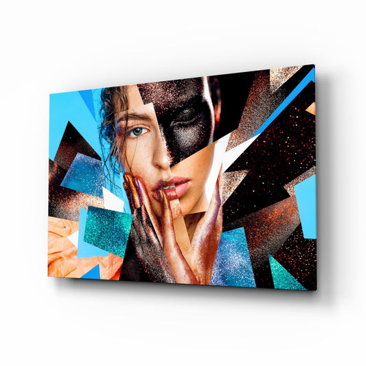 Angled perspective of glass wall art featuring a woman's face with turquoise, copper, and black geometric shards overlaid on blue background.