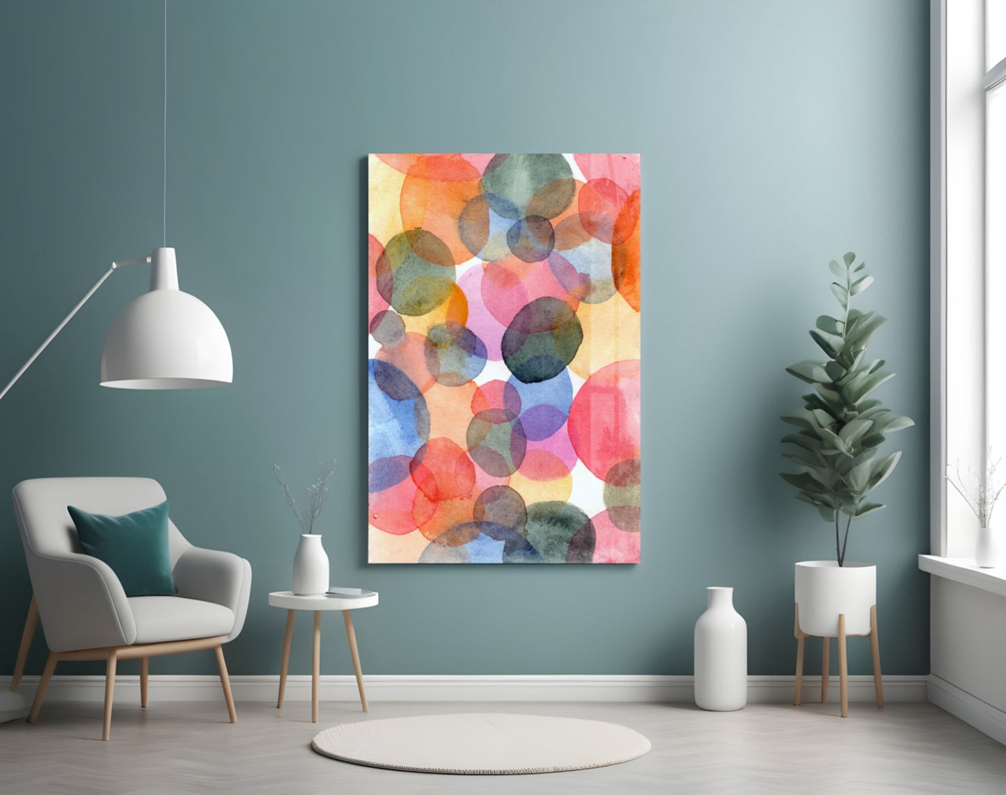 Colorful watercolor glass wall art with overlapping translucent circles in red, pink, blue, yellow, and green tones displayed in a modern room setting.