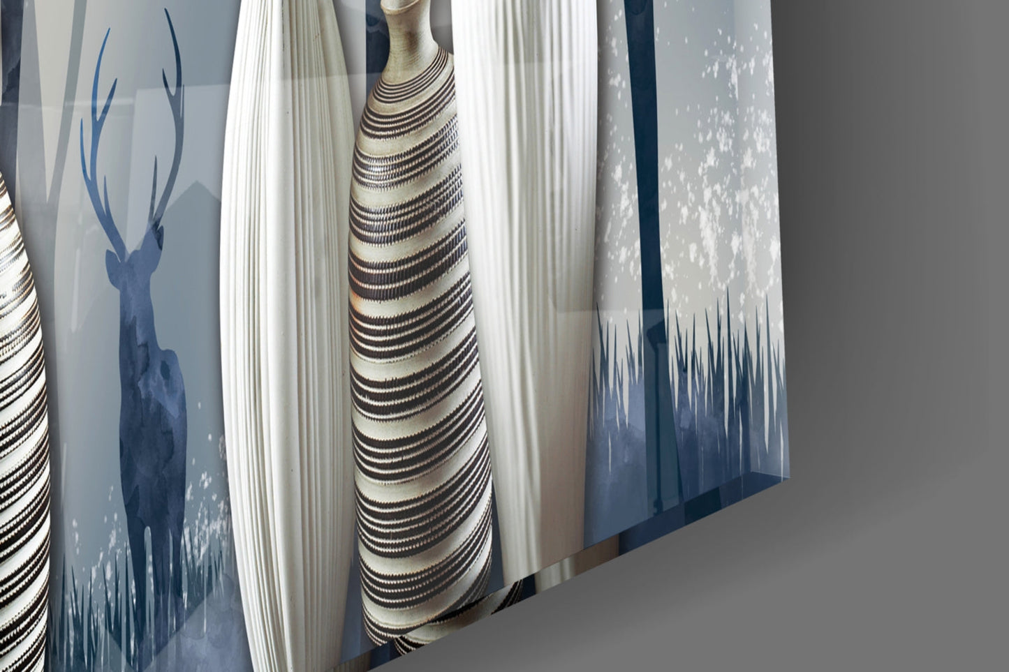 Display of glass wall art panels featuring silhouetted deer and forest designs in blue and cream tones.