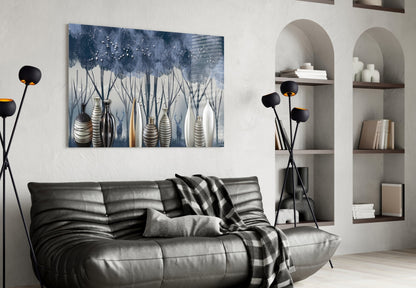 Modern living room with blue and white glass wall art featuring vases and flowering plants above a black leather sofa.