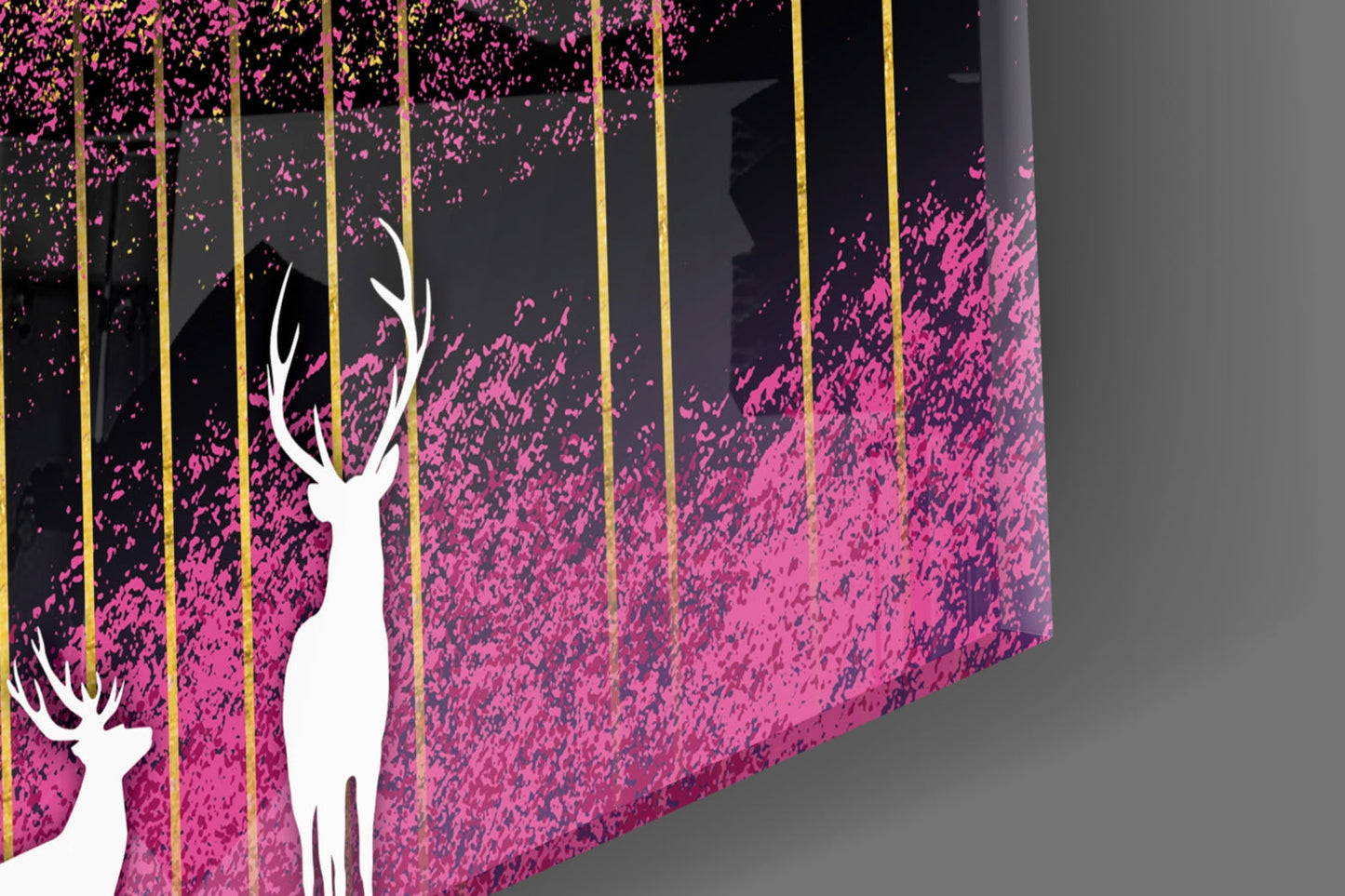 Close-up angled view of glass wall art featuring white deer silhouettes against pink and black textured background with gold vertical lines.