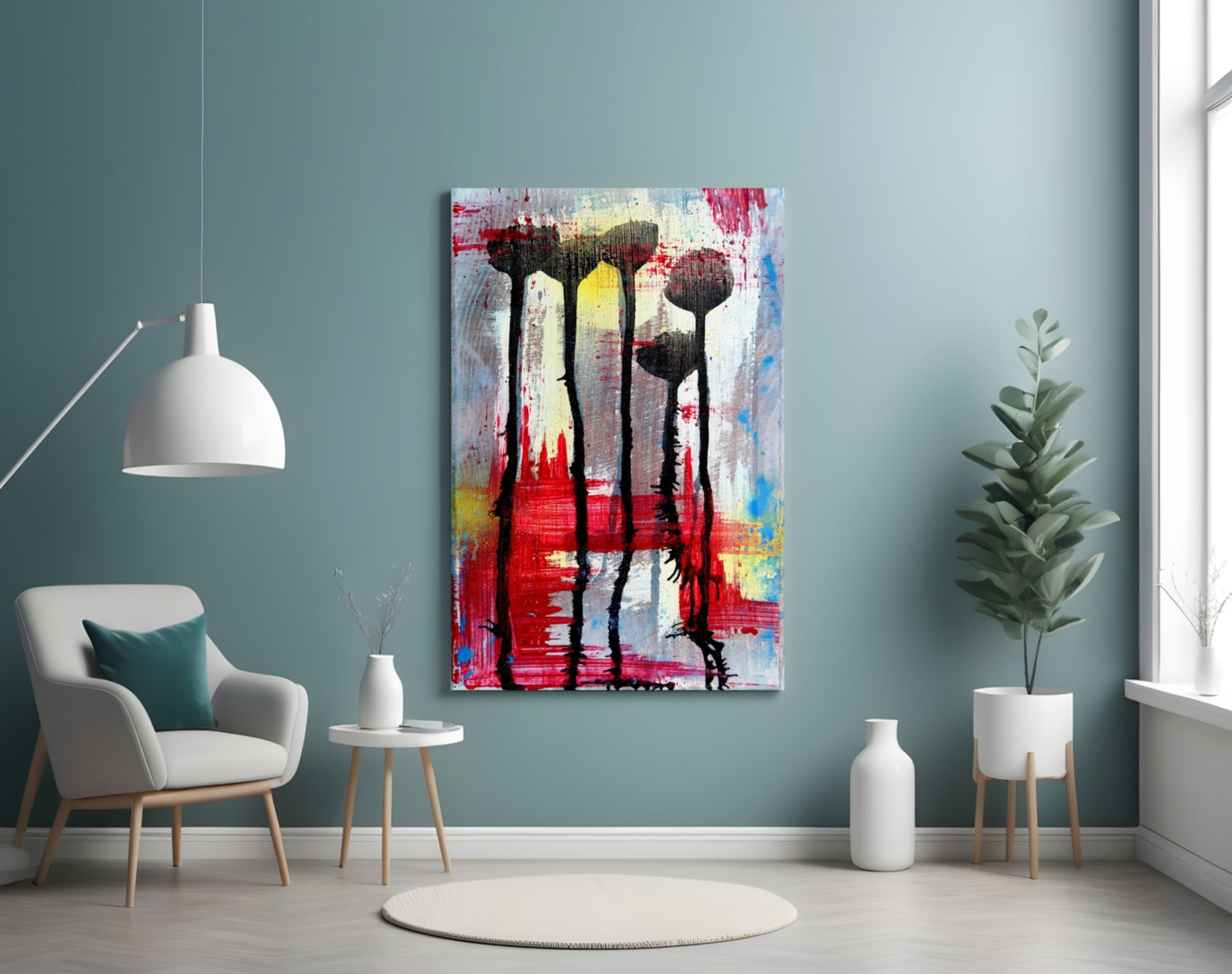 Abstract flower silhouettes glass art with red, yellow, and blue paint strokes displayed on teal wall above white chair.