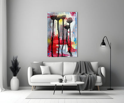 Colorful glass wall art with silhouetted flowers displayed above white sofa in modern living room interior.