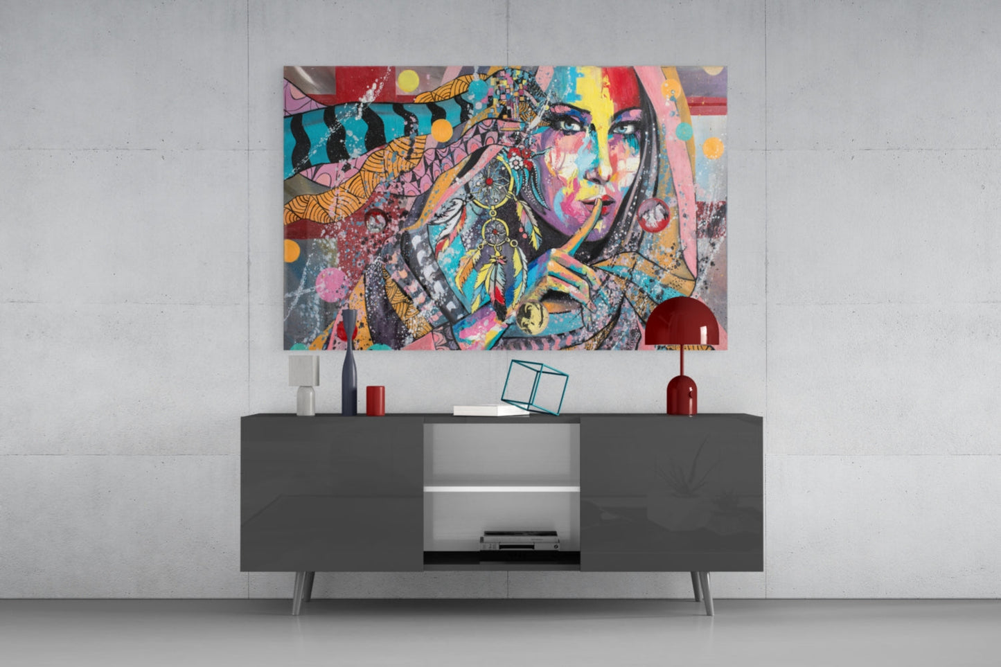 Colorful pop art glass wall art featuring a woman's face with vibrant geometric patterns displayed above a dark modern console table.
