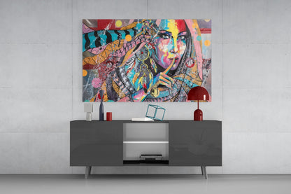 Colorful pop art glass wall art featuring a woman's face with vibrant geometric patterns displayed above a dark modern console table.