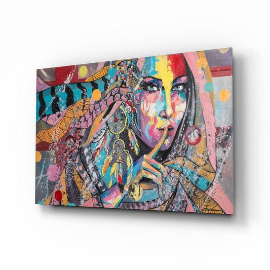 Colorful glass wall art featuring a woman's face decorated with vibrant patterns, feathers, and geometric designs in rainbow hues, displayed at an angled perspective.