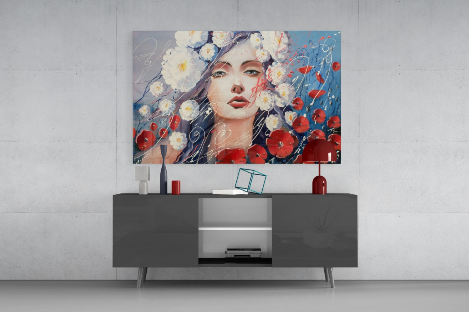 Modern living room setting with glass wall art depicting a woman's face surrounded by white daisies and red poppies, mounted above a dark gray media console.
