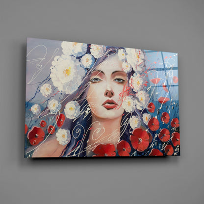 Glass wall art featuring a woman's face surrounded by white daisies and red poppies with decorative script overlay, displayed against a gray wall.