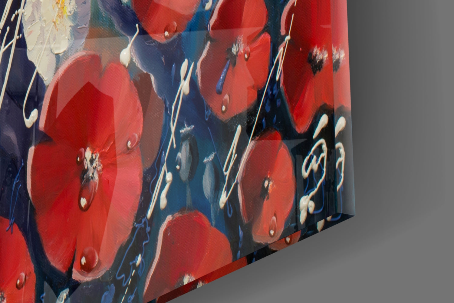 Angled close-up view of glass wall art displaying red flowers with white stamens on dark blue background.