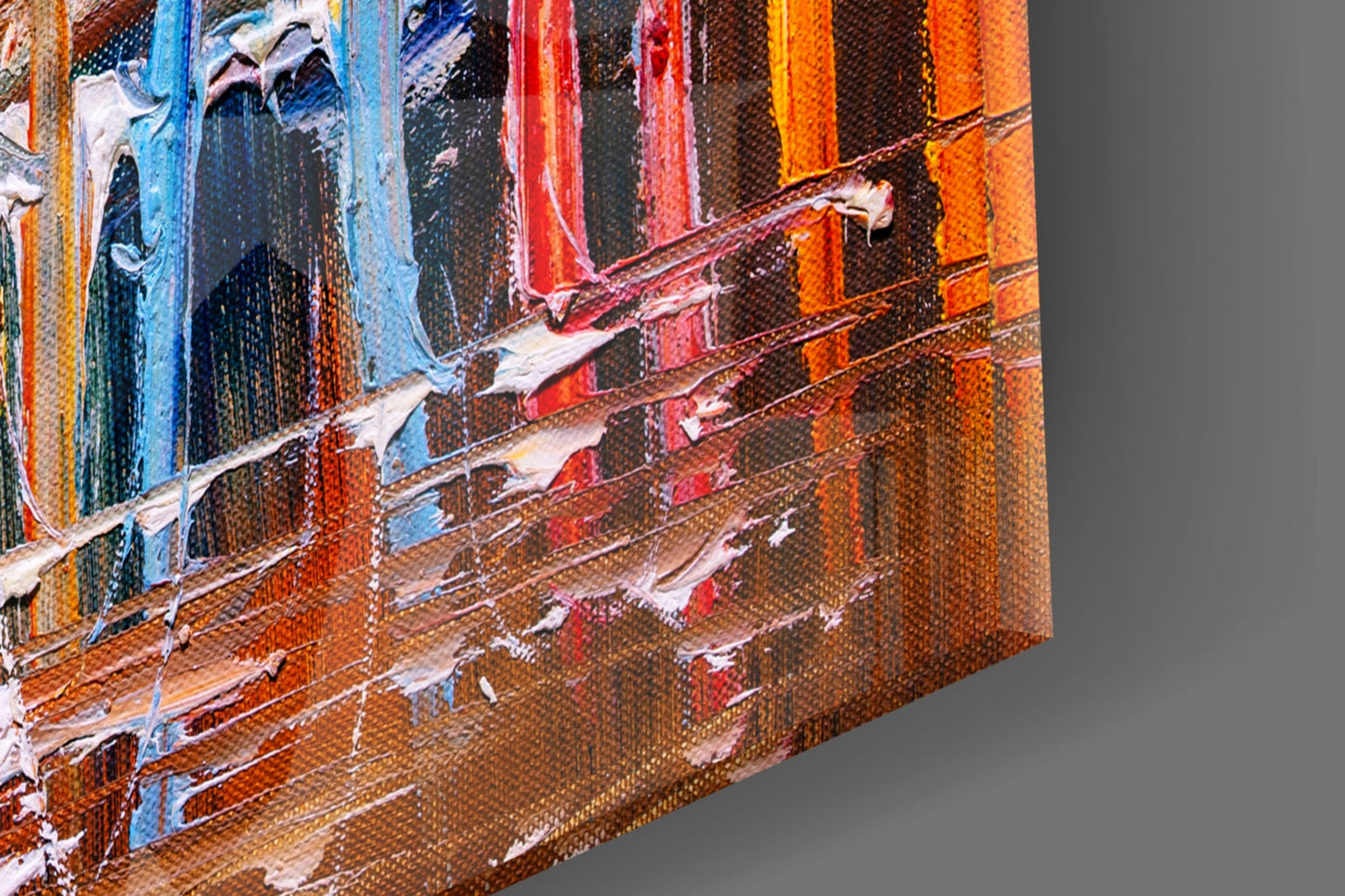 Close-up angled view of textured canvas showing colorful vertical stripes in blue, red, orange, and brown with white brushstroke details.