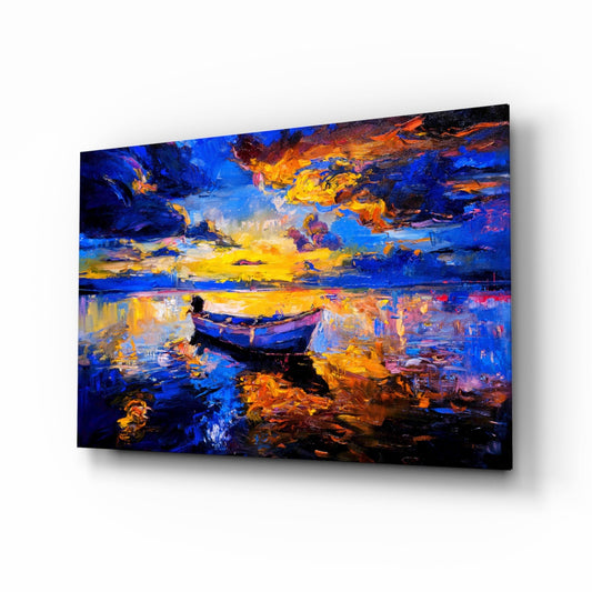 Angled perspective view of glass wall art depicting a solitary blue boat on water under a dramatic sunset sky in vibrant blues, oranges, and yellows.