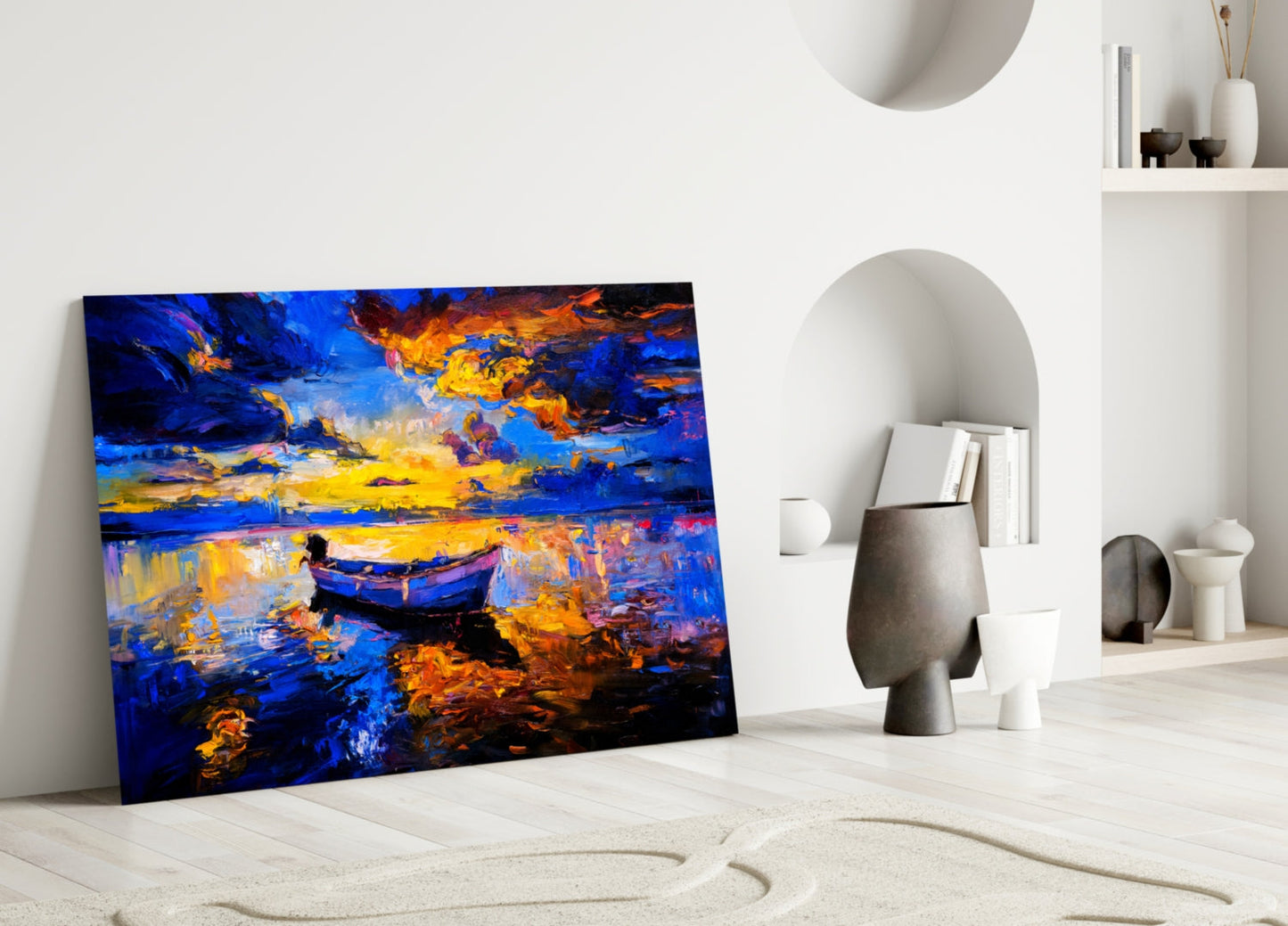 Dark blue glass wall art leaning against white wall displays golden sunset over water with silhouetted boat.