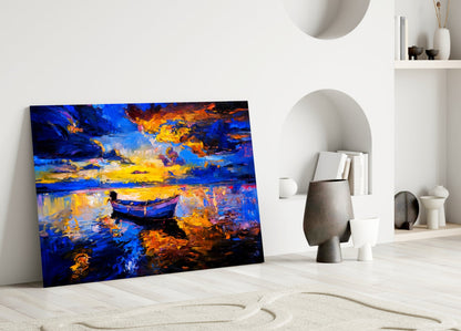 Dark blue glass wall art leaning against white wall displays golden sunset over water with silhouetted boat.
