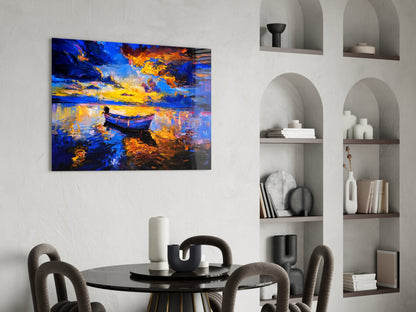 Dark blue glass wall art depicting a golden-lit boat on water, displayed above a round black dining table with modern chairs in a minimalist interior.