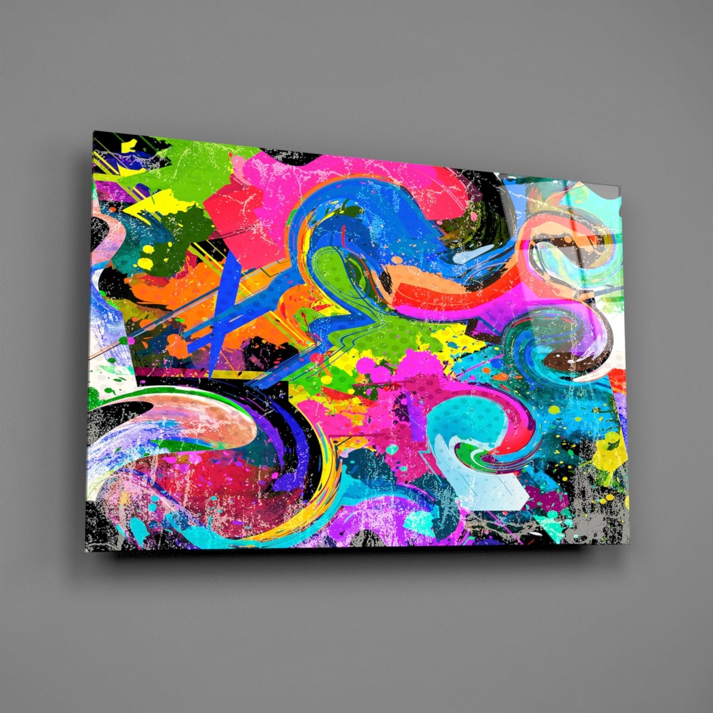 Colorful abstract Ebruli glass wall art featuring vibrant swirls of pink, blue, green, yellow, and black paint splatters on a rectangular panel displayed against a gray background.