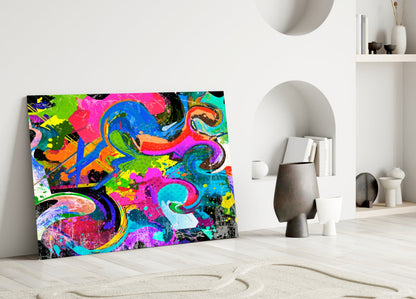 Vibrant Ebruli glass wall art with neon pink, blue, green, and yellow abstract swirls displayed against white wall in minimalist interior.