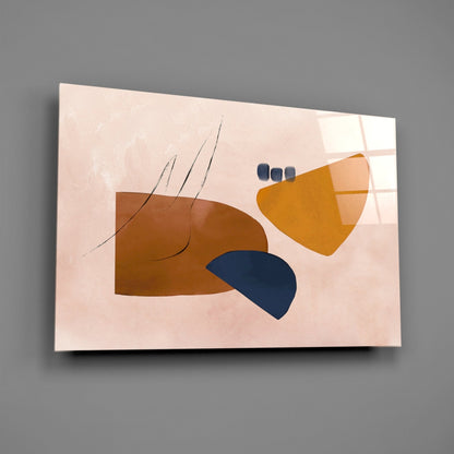 Abstract brown glass wall art featuring geometric shapes in brown, gold, and navy blue on a pale pink background, displayed at an angle against a gray wall.
