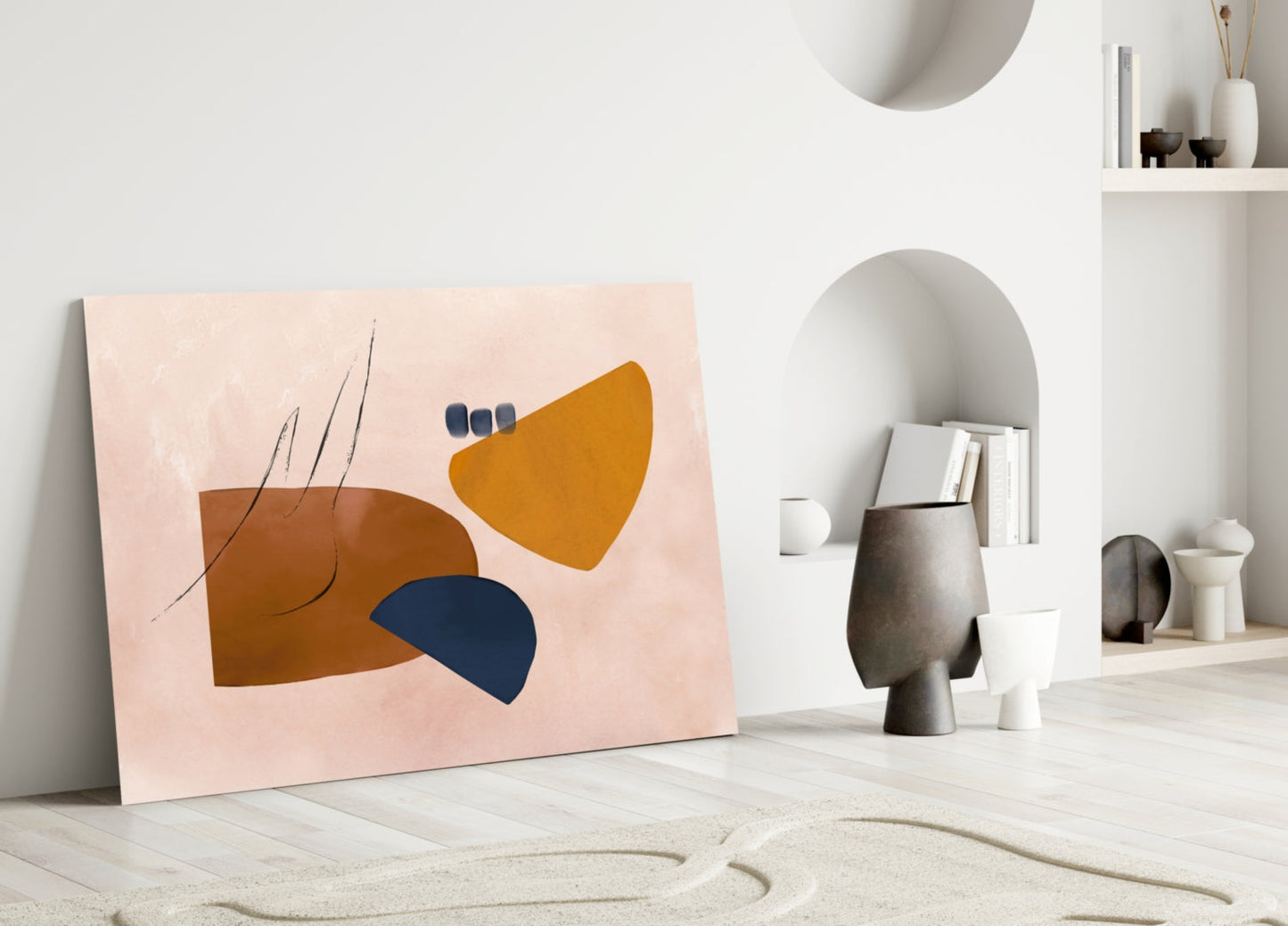 Abstract artwork with pink background featuring brown, gold, and navy blue shapes with thin line details, leaning against white wall in minimalist interior.