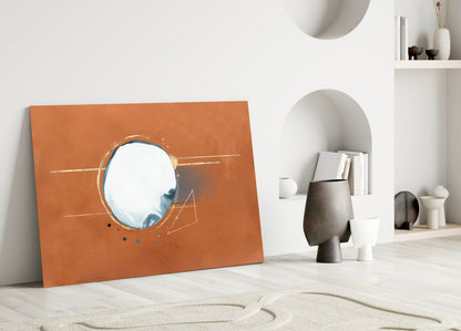 Abstract Cinnamon Glass Wall Art leaning against white wall beside decorative vessels and shelving unit with books and ceramics.