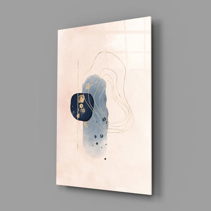 Abstract beige glass wall art displayed at an angle, showing blue watercolor wash, gold leaf accents, tan line drawings, and black dots on cream background.