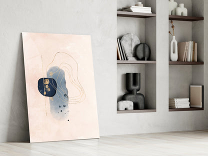 Abstract beige glass wall art leaning against white wall beside shelving unit, featuring blue and gold geometric design with curved lines.