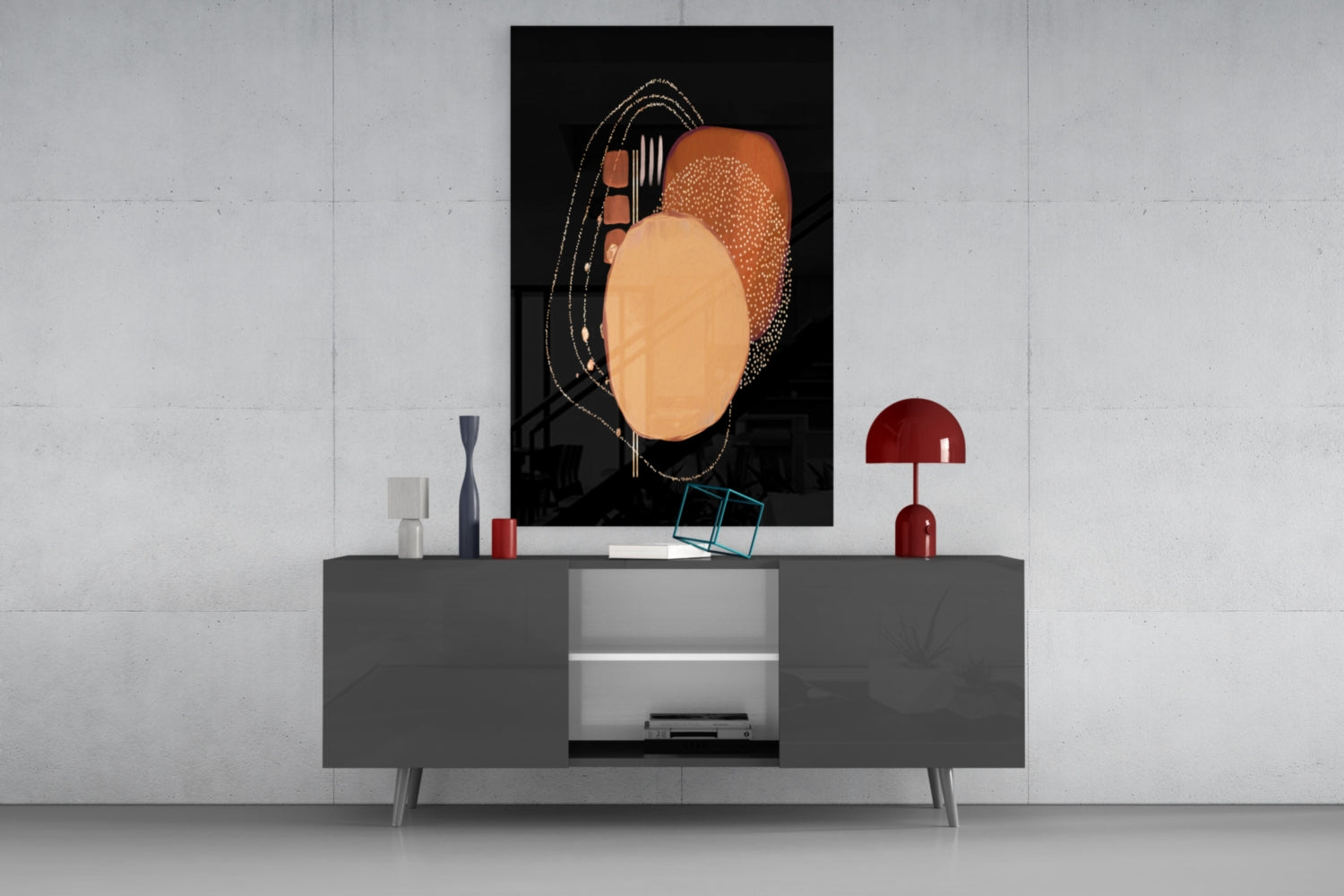 Abstract black glass wall art with orange and terracotta circular shapes and gold line details displayed above gray media console.