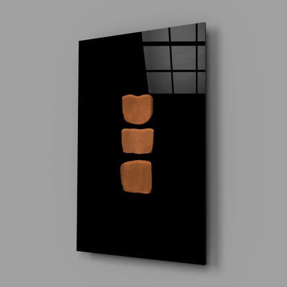 Black glass wall panel with three orange-brown rounded rectangles arranged vertically, displayed at an angle against gray background.