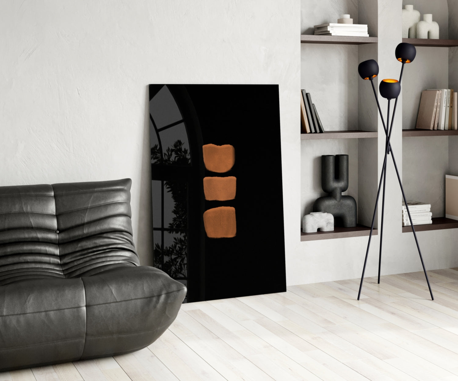 Modern living room interior featuring black glass wall art with three orange rounded square shapes displayed against white shelving and gray leather furniture.
