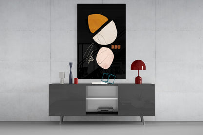 Abstract acorn glass wall art with orange and cream shapes displayed above gray media console in modern interior setting.