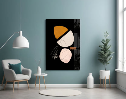 Abstract acorn glass wall art with orange, cream, and black geometric shapes displayed in a contemporary living room setting with teal walls and modern furniture.