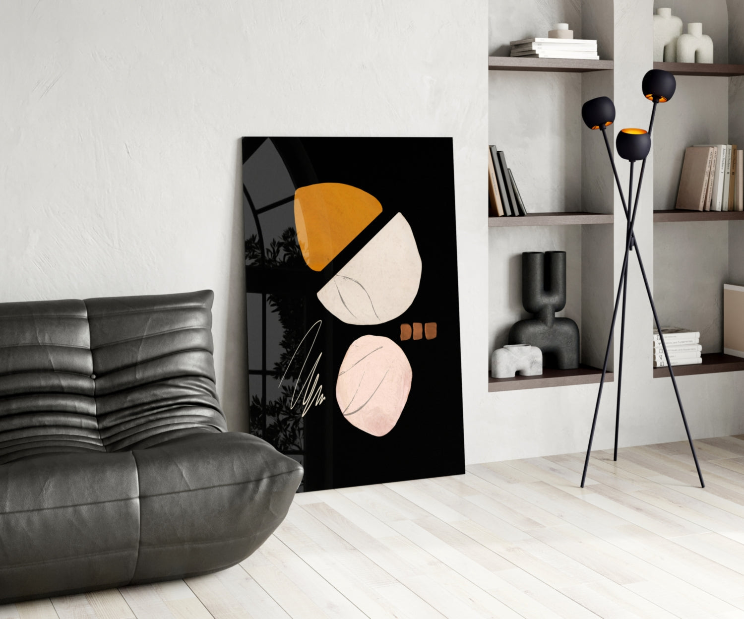 Modern living room with black glass wall art featuring orange and cream acorn design displayed next to gray leather sofa.
