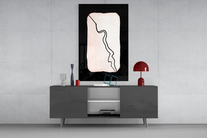 Modern living room interior with abstract black and white glass wall art displayed above gray console table with red accents.