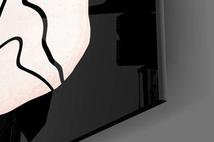 Close-up of translucent glass wall art with black curved outline against dark interior architectural background.
