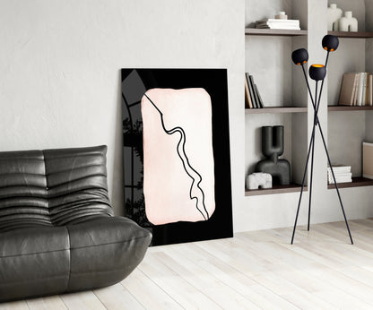 Modern living room interior featuring a black-framed glass wall art with cream background and continuous black line design, displayed between gray leather sofa and white shelving unit.