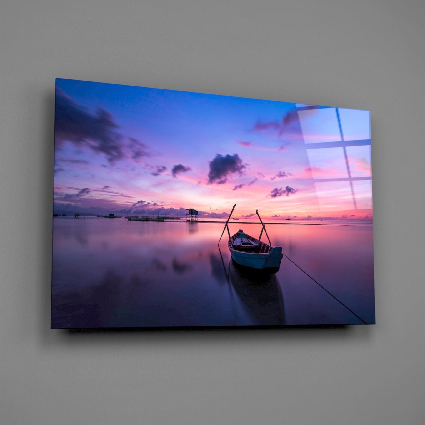Glass wall art displaying a twilight seascape with moored fishing boat, pink and purple sky, and calm water reflections.