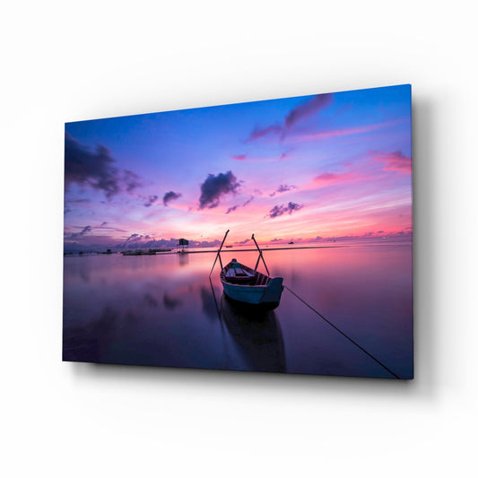A fishing boat with raised oars floats in calm water under a pink and purple sunset sky, displayed as glass wall art.