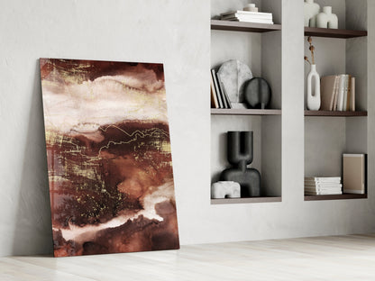 Abstract earth-toned glass panel leaning against white wall beside built-in shelving with decorative objects and books.