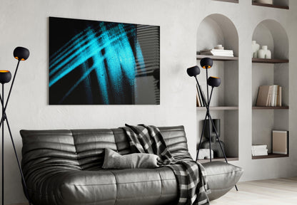 Blue Lights Glass Wall Art displayed above a gray leather sofa in a modern living room with white built-in shelving.